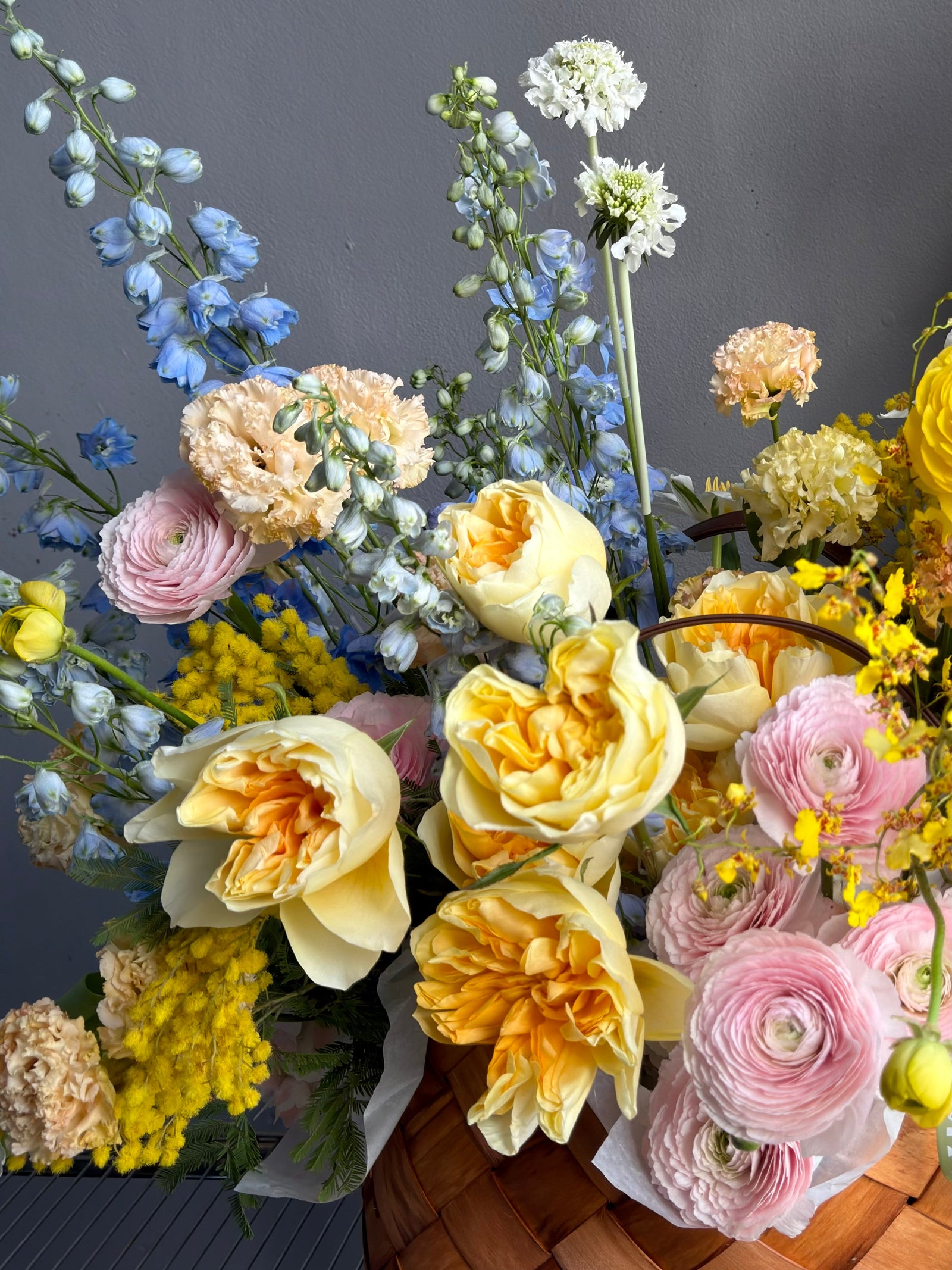 Flower Basket “Hello, Sunshine!” — ranunculus, roses, delphinium, carnations, mimosa &amp; seasonal blooms