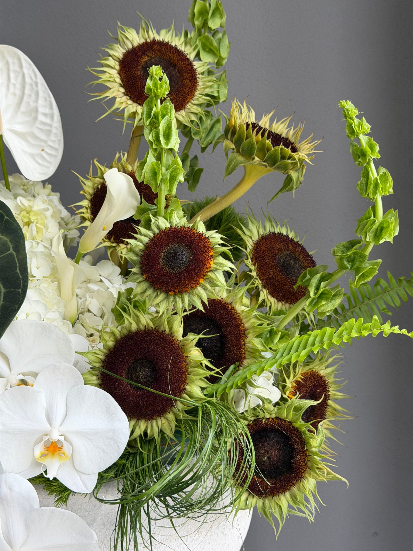 Interior Arrangement “Modern Muse” — orchid, anthurium, sunflower, calla lilies