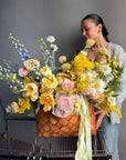 Flower Basket “Hello, Sunshine!” — ranunculus, roses, delphinium, carnations, mimosa & seasonal blooms